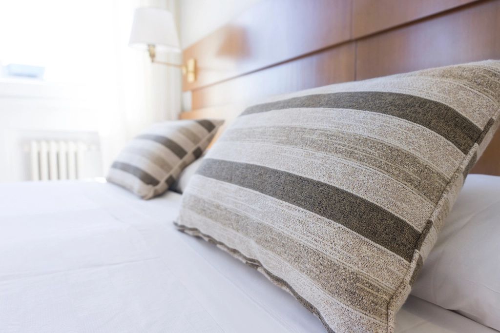 A guest room with a large bed and soft lighting